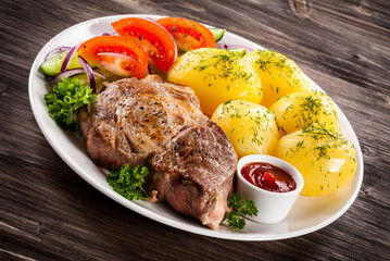 Grilled steak, boiled potatoes and vegetable salad