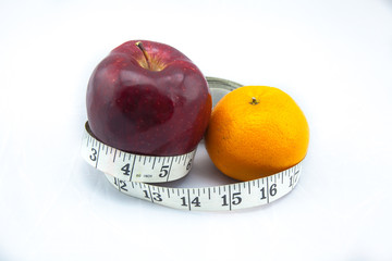 Red Apple and Orange with Measure Tape on White Background