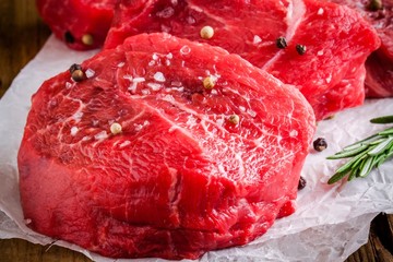 raw steaks with rosemary, sea salt and pepper