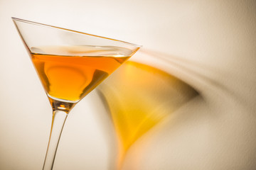 Orange liqueur into a martini glass. 