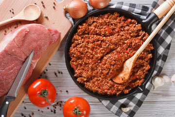 Bolognese sauce cooking in a frying pan horizontal top view