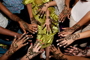 Henna tattoo in a bride hand and her guess for wedding