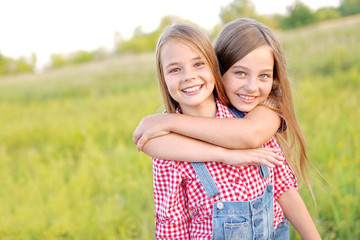 Portrait of two beautiful girlfriends on the nature