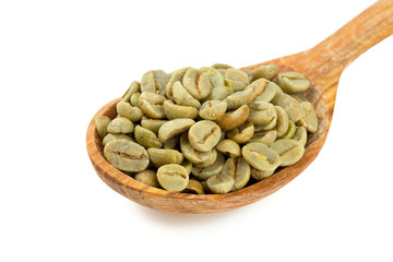 green coffee beans in a wooden spoon