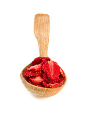 Dehydrated sliced strawberries in a wooden spoon