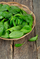 spinach in a basket on wooden surface