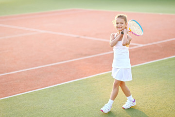 portrait of a little girl on the tennis court