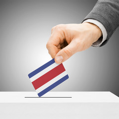 Voting concept - Male inserting flag into ballot box - Costa Ric