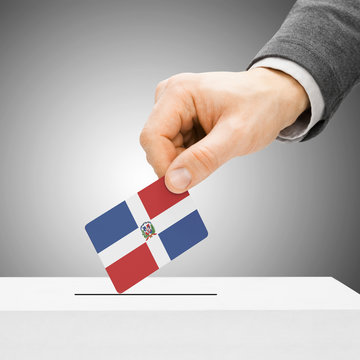 Voting concept - Male inserting flag into ballot box - Dominican
