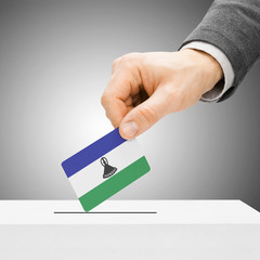 Voting concept - Male inserting flag into ballot box - Lesotho