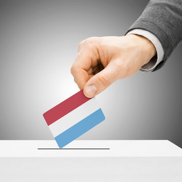 Voting concept - Male inserting flag into ballot box - Luxembour