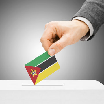 Voting concept - Male inserting flag into ballot box - Mozambiqu
