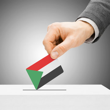 Voting concept - Male inserting flag into ballot box - Sudan
