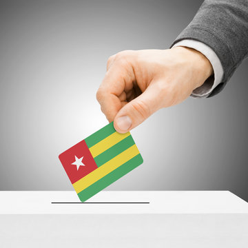 Voting concept - Male inserting flag into ballot box - Togo