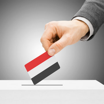 Voting concept - Male inserting flag into ballot box - Yemen