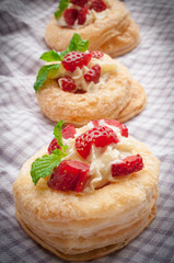 Strawberry Tart with Fresh Cream in Puff Pastry on wooden mat