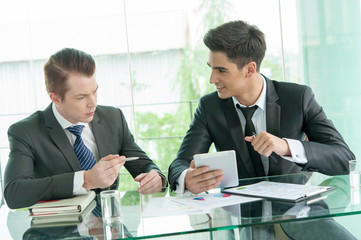 Two businessman using tablet in meeting