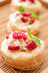 Strawberry Tart with Fresh Cream in Puff Pastry on wooden mat