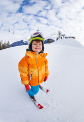 Fototapeta na wymiar Cheerful boy wearing ski mask and helmet skiing