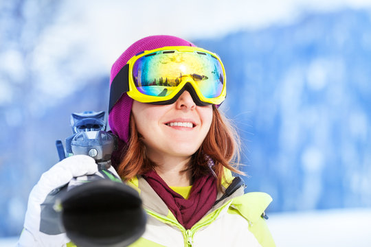 Portrait of happy woman in mask holding ski