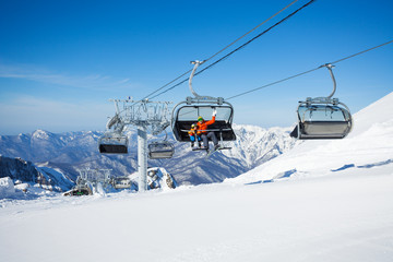 Fototapeta na wymiar Skiers on the chairlift ropeway winter resort