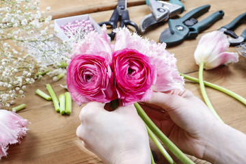 Fototapeta na wymiar Woman making beautiful bouquet of pink persian buttercup