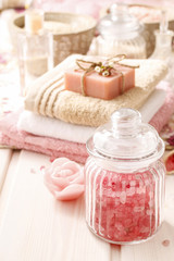 Obraz na płótnie Canvas Glass jar of pink sea salt on white wooden table
