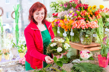 Floristin bindet Blumenstrauß im Laden