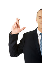 Businessman making a wish with fingers crossed