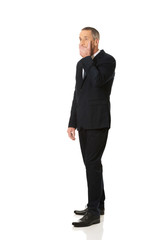 Full length businessman covering mouth