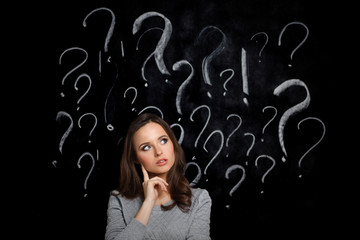 Young girl with question mark on a gray background