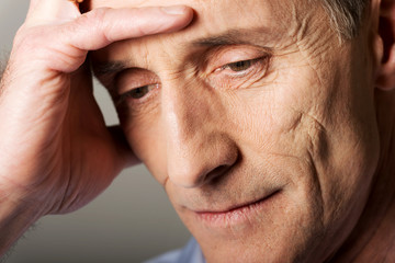 Depressed mature man touching his head