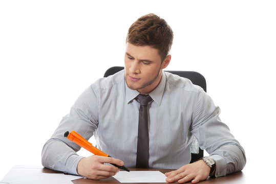 Young business man writing a note.