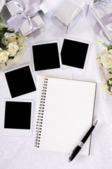 Wedding gifts white lace background with photo album and polaroid style picture frame or guest and...