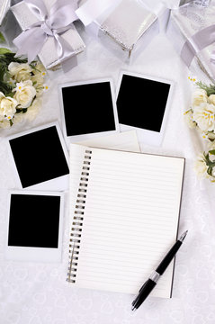 Wedding gifts white lace background with photo album and polaroid style picture frame or guest and present list