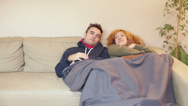Women and man resting together on the sofa at home.