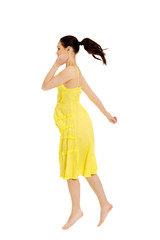 Beautiful woman jumping in yellow dress.