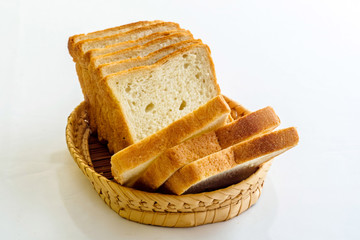 Sliced bread in wicker basket isolated on white