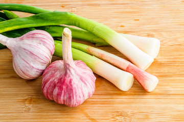 Young green garlic on wooden board