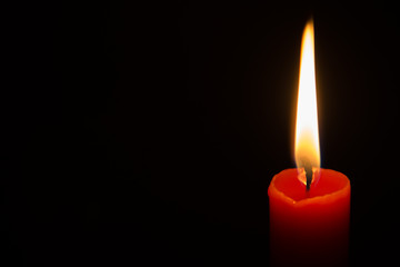 Red candle in the dark.