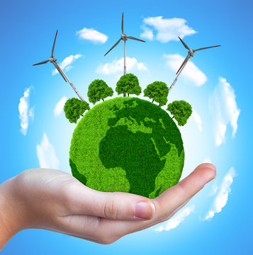 Green planet with trees and wind turbines in hand.