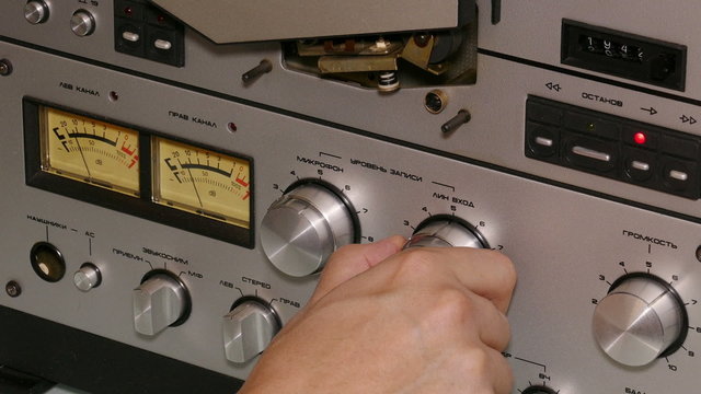 hand man operates reel tape recorder