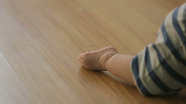 a little funny baby crawling on the floor, back view