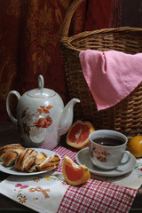Tea with a swiss roll and grapefruit