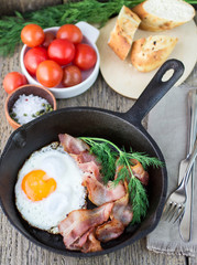 fried eggs with bacon on a frying pan