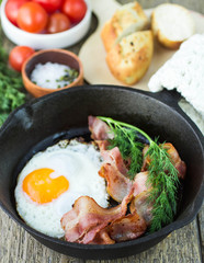fried eggs with bacon on a frying pan