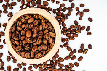 Coffee beans in wooden bamboo mortar isolated on white