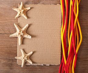 paper, rope and starfish on old wooden background