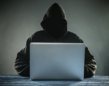 A hacker with a hood with laptop