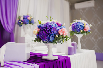 Beautiful flowers and candles on table in wedding day. Violet